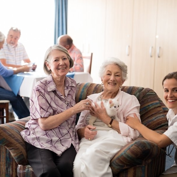 Portrait of female practitioner with kitten at nursing home